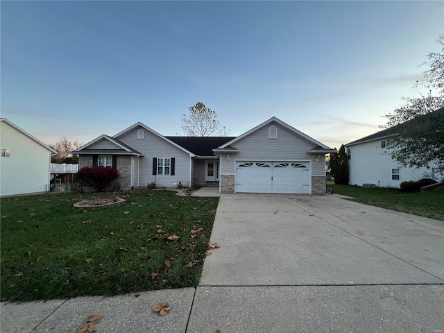 ranch-style home featuring a garage and a lawn