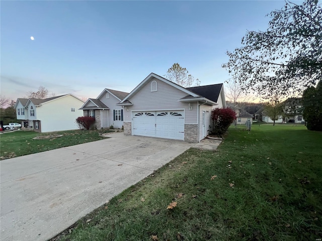 single story home with a garage and a lawn