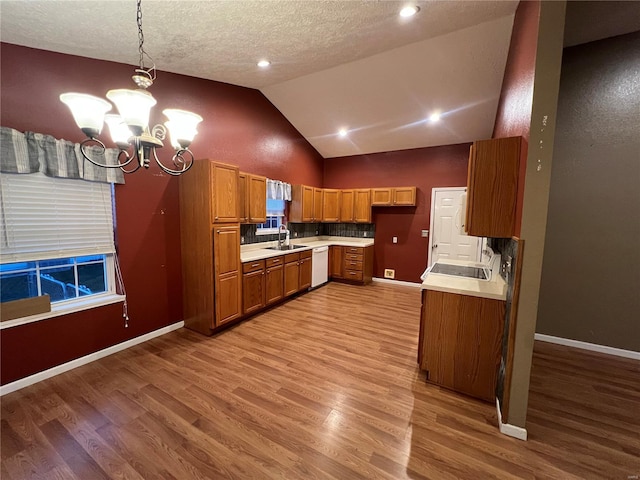 kitchen with lofted ceiling, an inviting chandelier, a textured ceiling, pendant lighting, and light wood-type flooring