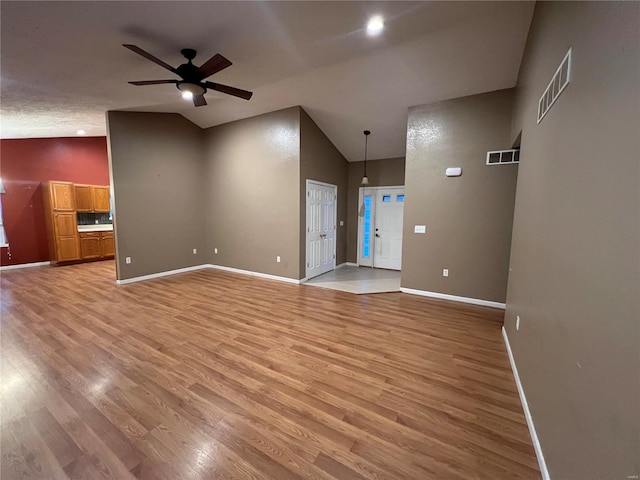 unfurnished living room with light hardwood / wood-style floors, ceiling fan, and high vaulted ceiling