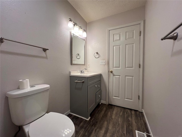 bathroom with vanity, wood-type flooring, a textured ceiling, and toilet