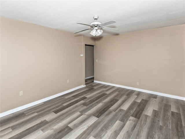 empty room with dark hardwood / wood-style floors and ceiling fan