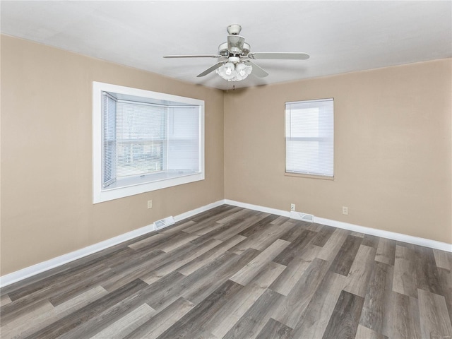 spare room with dark hardwood / wood-style flooring and ceiling fan