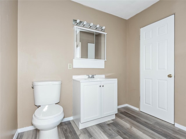 bathroom with hardwood / wood-style floors, vanity, and toilet