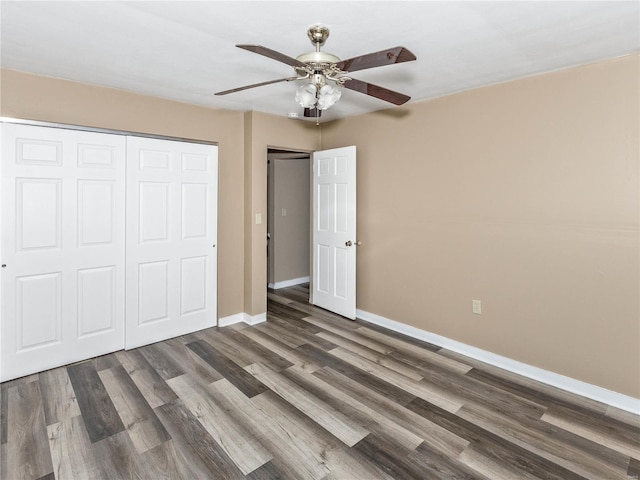 unfurnished bedroom with ceiling fan, a closet, and dark wood-type flooring