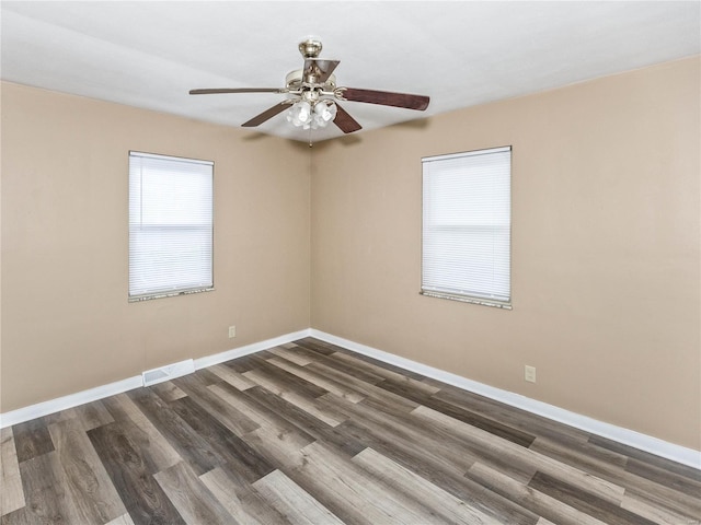 spare room with ceiling fan and dark wood-type flooring