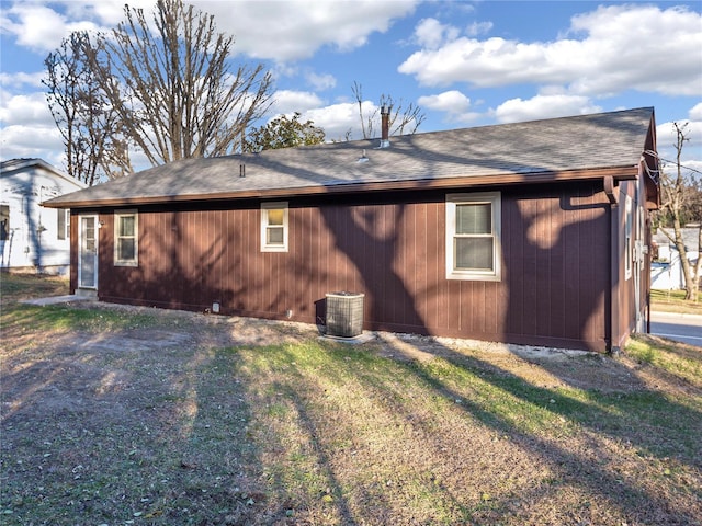 exterior space featuring central AC unit and a lawn