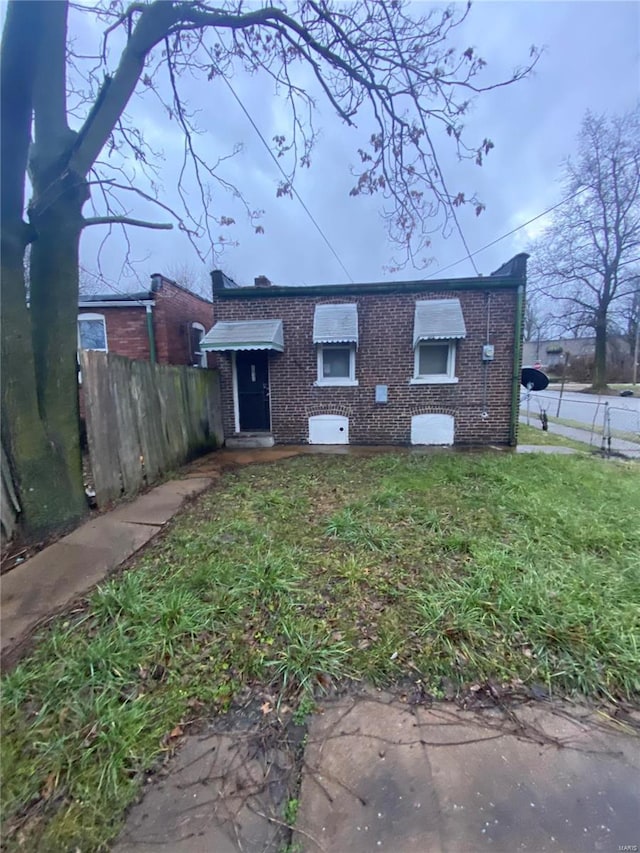 rear view of house featuring a lawn