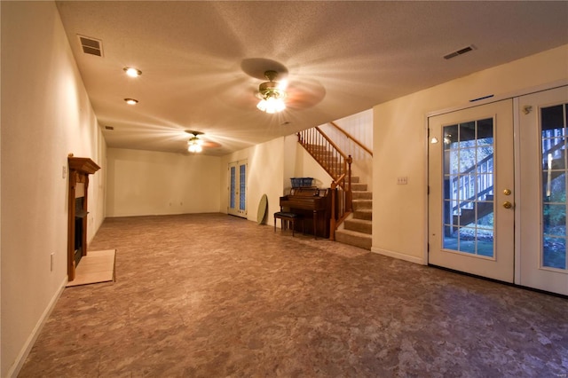 unfurnished living room featuring ceiling fan, a textured ceiling, and french doors