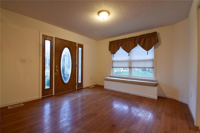 entryway with dark hardwood / wood-style flooring and a textured ceiling