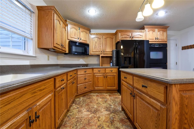 kitchen featuring black appliances, pendant lighting, sink, and a textured ceiling