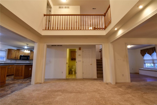 unfurnished living room with carpet and a towering ceiling