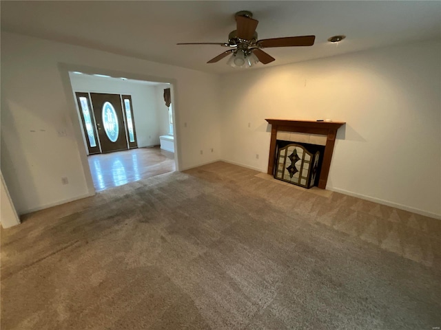 unfurnished living room with carpet and ceiling fan