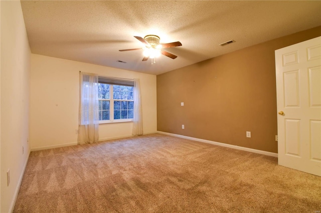 carpeted spare room with ceiling fan and a textured ceiling