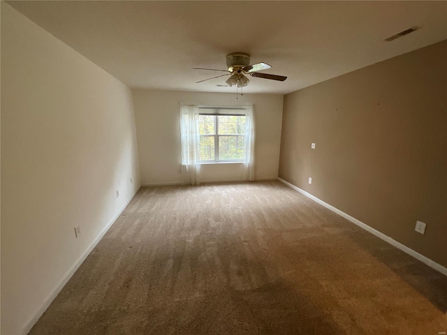 carpeted spare room with ceiling fan