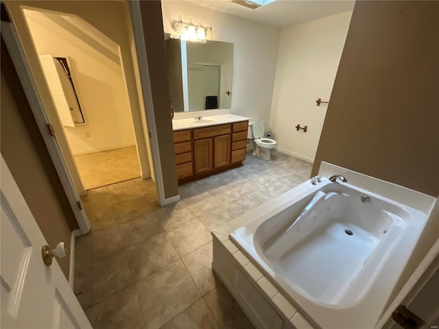 bathroom featuring a skylight, a bathing tub, tile patterned floors, toilet, and vanity