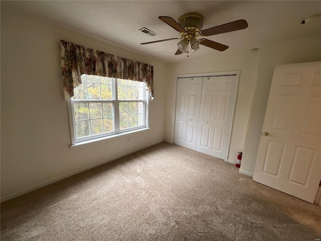 unfurnished bedroom with carpet flooring, ceiling fan, and a closet