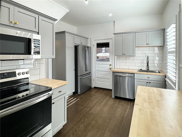 kitchen with gray cabinetry, sink, plenty of natural light, appliances with stainless steel finishes, and butcher block countertops