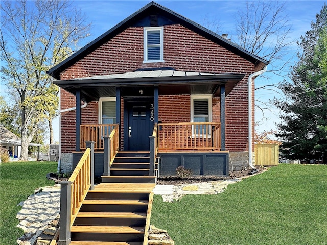 view of front of house featuring covered porch and a front yard