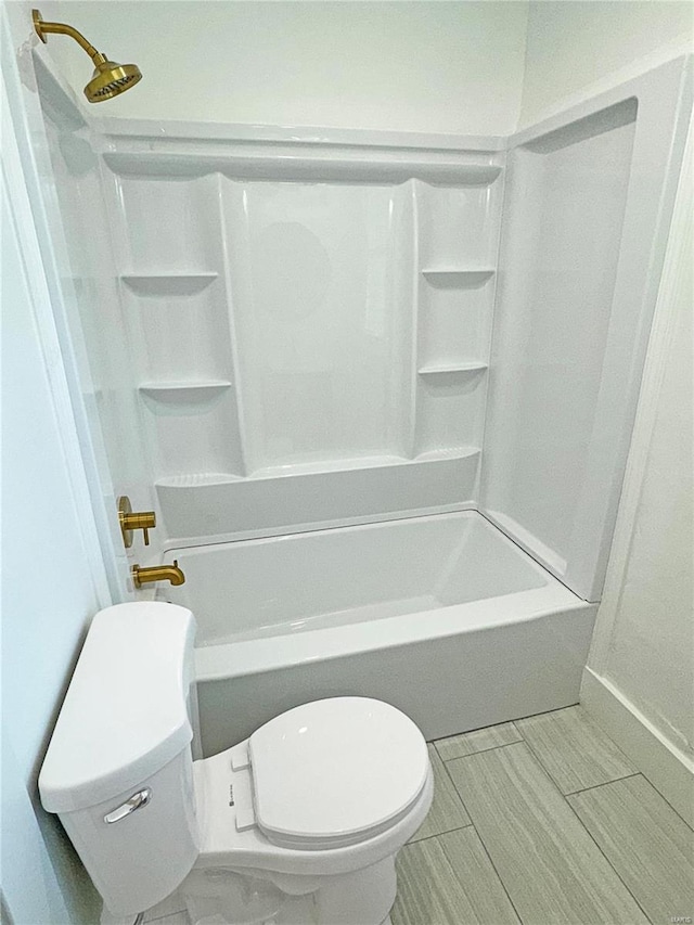 bathroom featuring shower / bathing tub combination and toilet