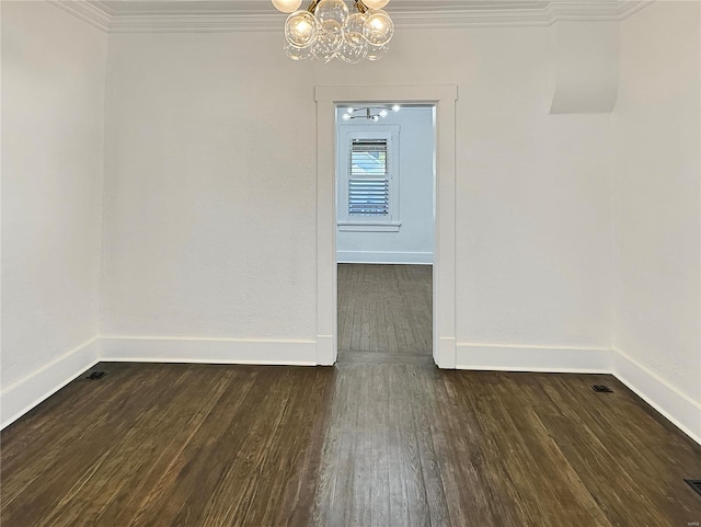 unfurnished room featuring dark wood-type flooring, an inviting chandelier, and crown molding