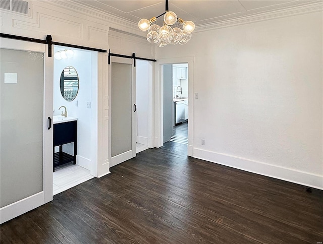 interior space featuring a barn door, crown molding, dark wood-type flooring, and a notable chandelier