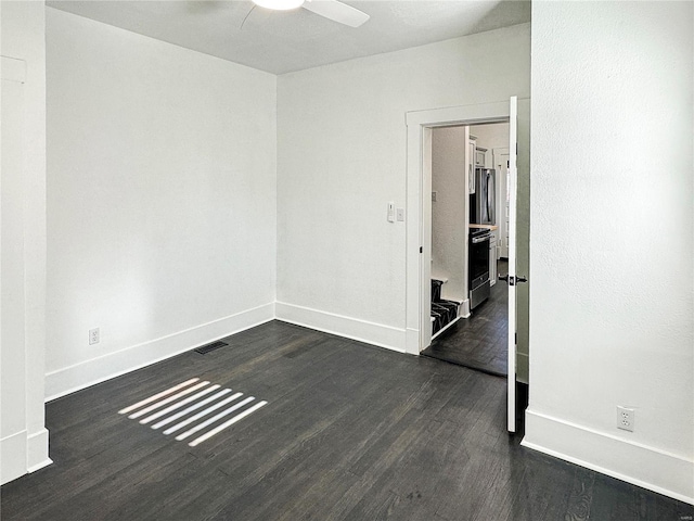 unfurnished room featuring ceiling fan and dark hardwood / wood-style floors