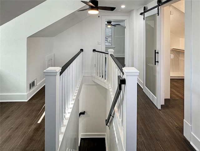 stairway with hardwood / wood-style floors and a barn door