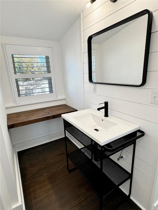 bathroom with wooden walls, hardwood / wood-style floors, and vanity