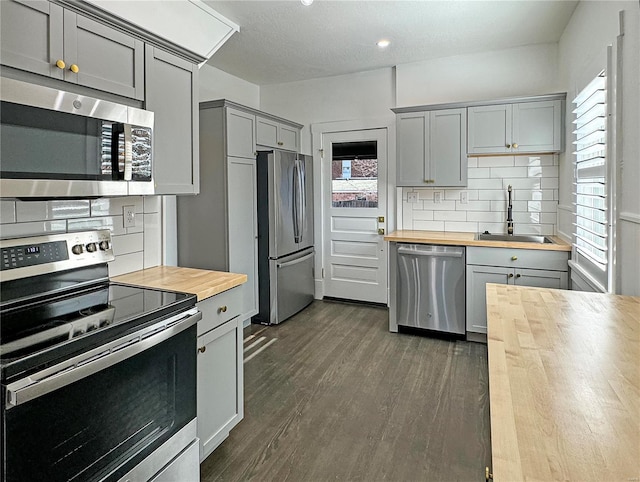 kitchen featuring butcher block counters, sink, plenty of natural light, and appliances with stainless steel finishes