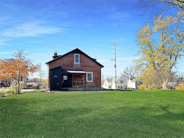 rear view of house featuring a lawn