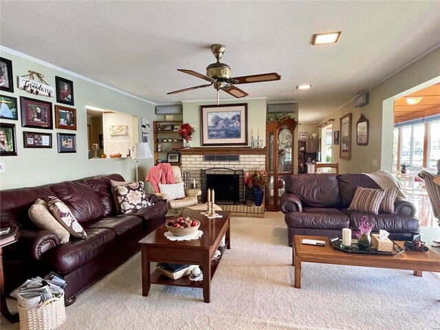 living room with ornamental molding, light carpet, ceiling fan, and a fireplace