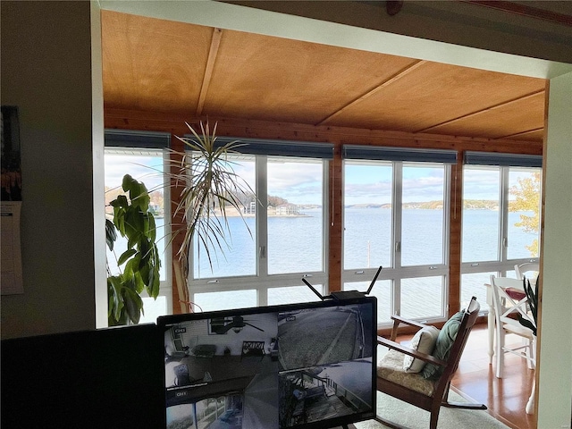 sunroom / solarium featuring a water view and wood ceiling