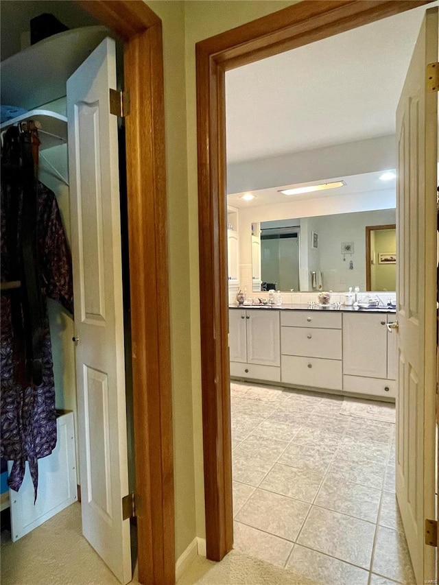 hallway featuring sink and light tile patterned flooring