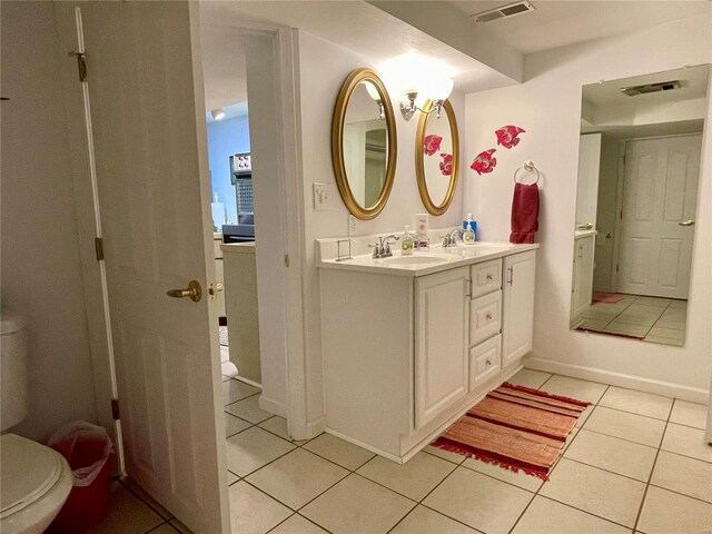 bathroom featuring tile patterned flooring, vanity, and toilet