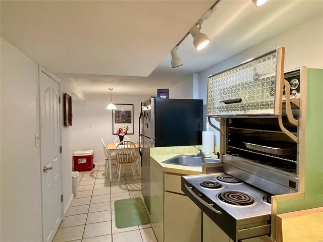 kitchen with fridge, sink, light tile patterned flooring, and rail lighting