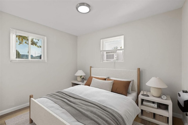 bedroom featuring multiple windows, cooling unit, and wood-type flooring