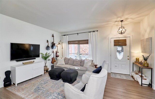 living room with an inviting chandelier and light hardwood / wood-style flooring