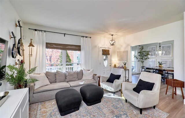 living room featuring an inviting chandelier and light hardwood / wood-style flooring