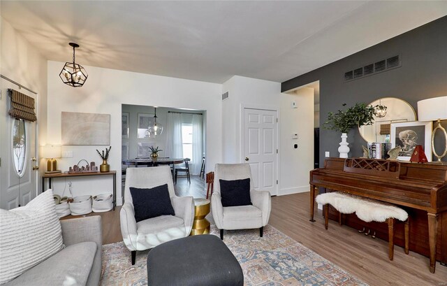 living room with hardwood / wood-style flooring and an inviting chandelier