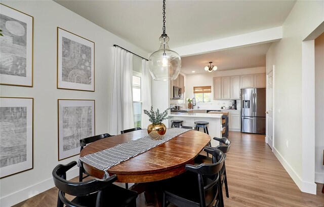 dining area featuring light hardwood / wood-style floors and a notable chandelier