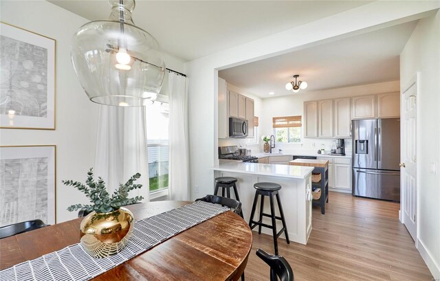 dining area featuring light wood-type flooring and a notable chandelier