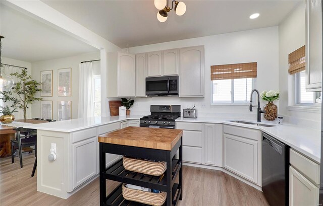 kitchen featuring a center island, light hardwood / wood-style floors, white cabinetry, and stainless steel appliances