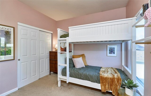 carpeted bedroom featuring multiple windows and a closet