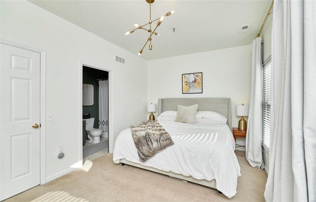 bedroom featuring light colored carpet, connected bathroom, and a chandelier