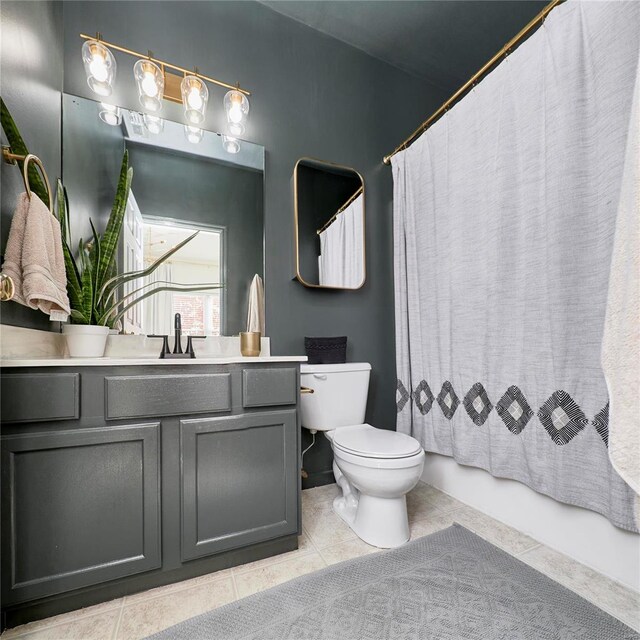 full bathroom featuring tile patterned floors, vanity, toilet, and shower / bath combo with shower curtain