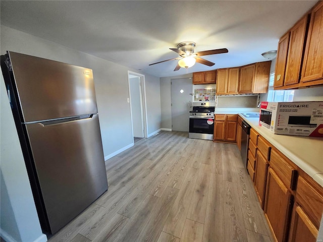 kitchen featuring light hardwood / wood-style floors, stainless steel appliances, sink, and ceiling fan