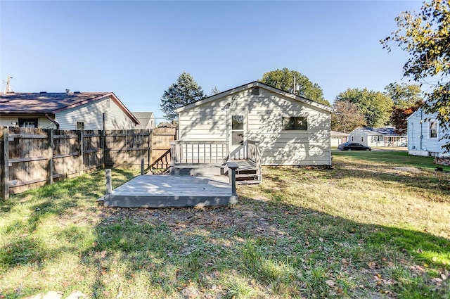 rear view of house featuring a deck and a yard