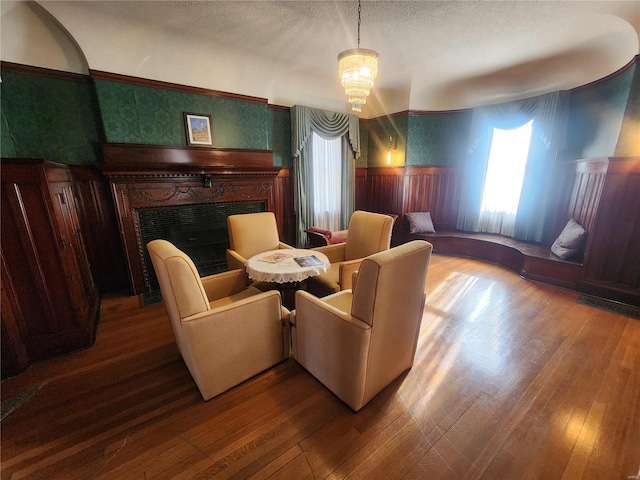 sitting room featuring a chandelier, hardwood / wood-style floors, and a textured ceiling