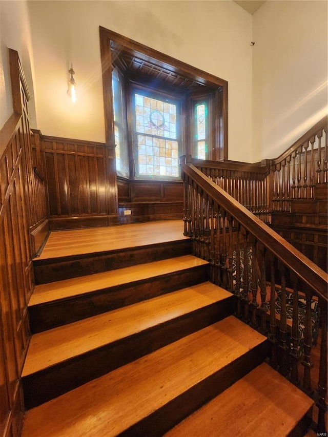 staircase featuring wood walls